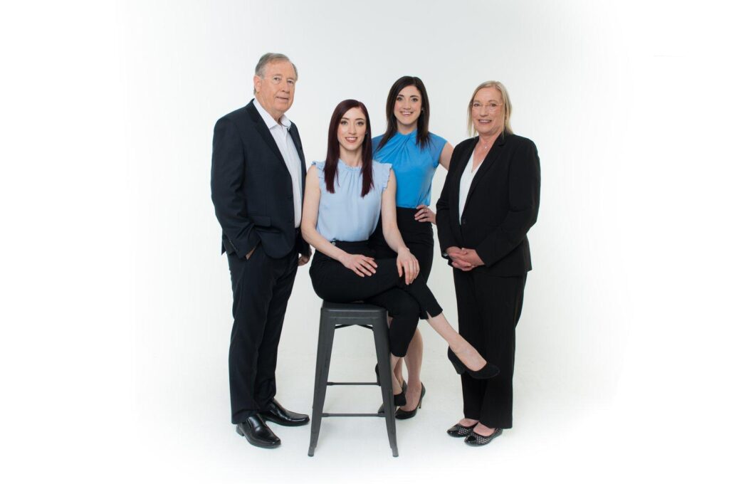 Four business professionals posing in studio portrait