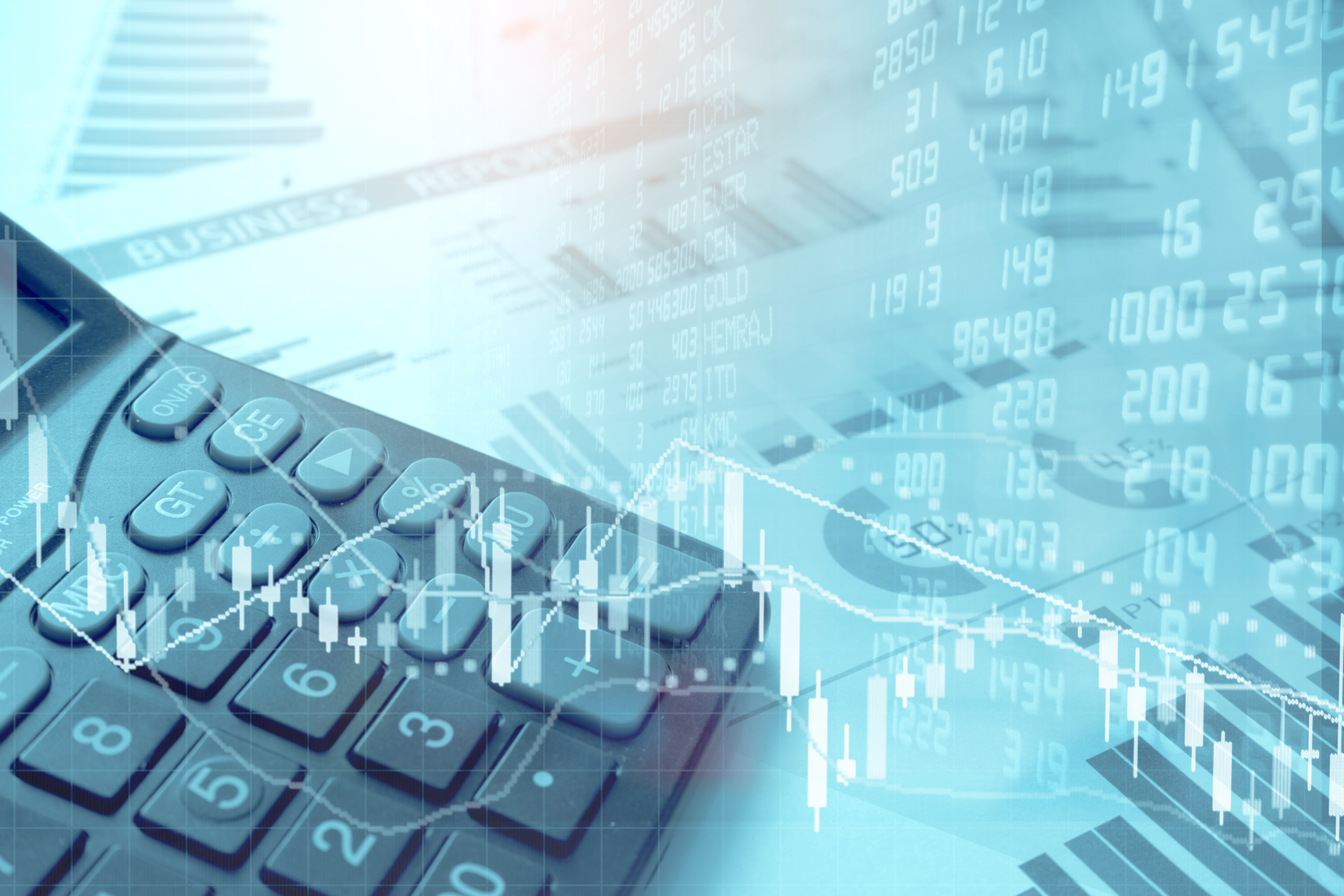 Calculator and stock market charts over business reports