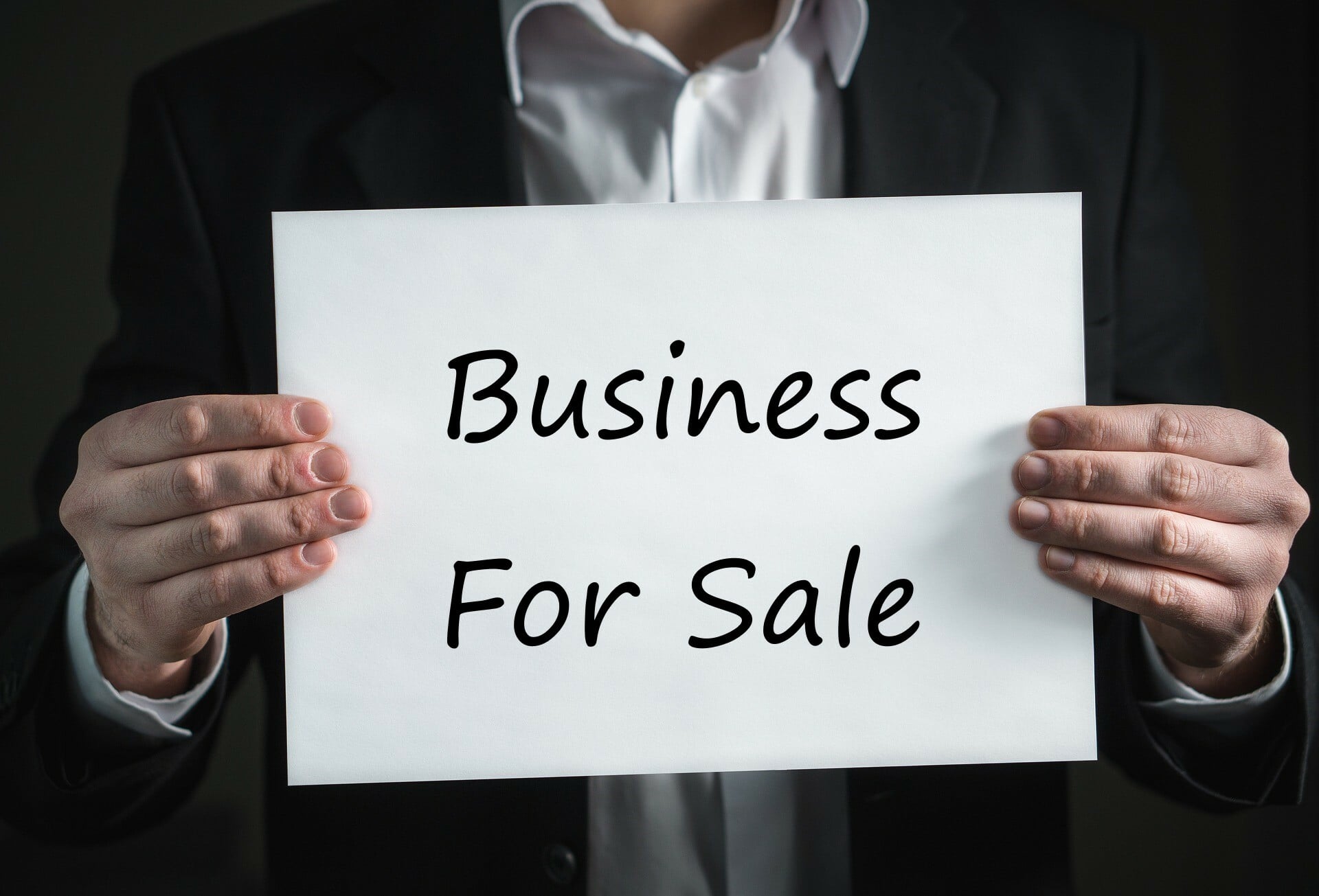 Man holding Business For Sale sign