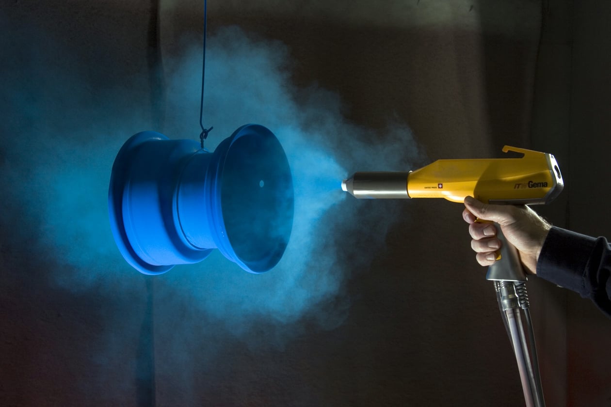 Powder coating spray gun painting blue wheel rim