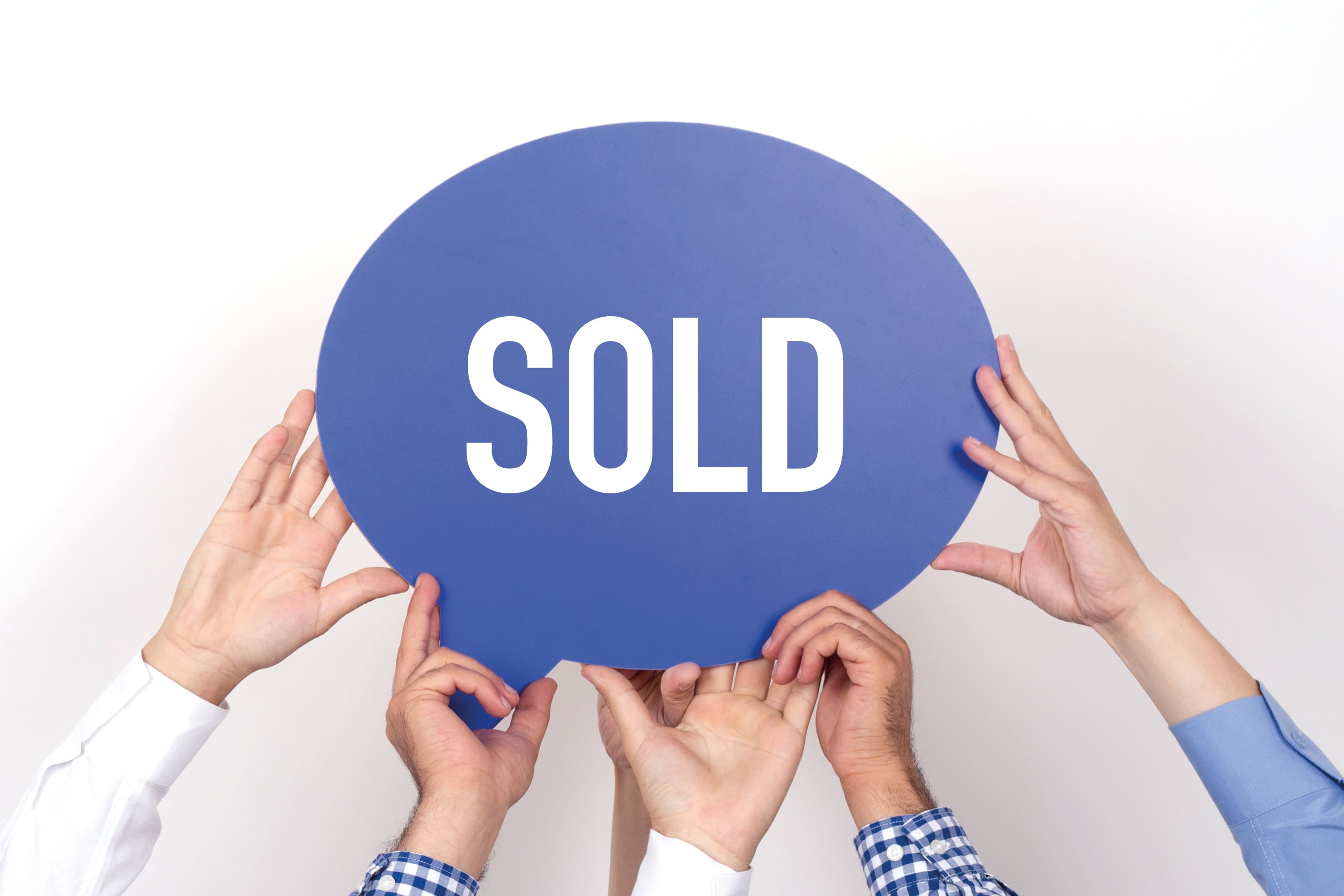 Hands holding blue speech bubble with SOLD text