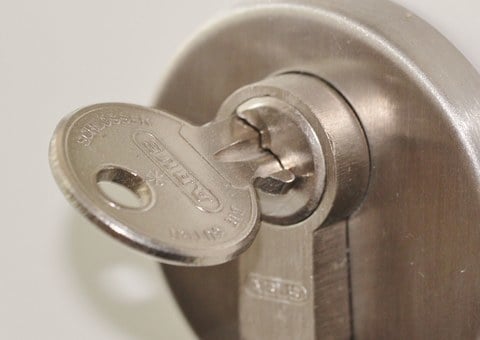 Key inserted into metal door lock cylinder