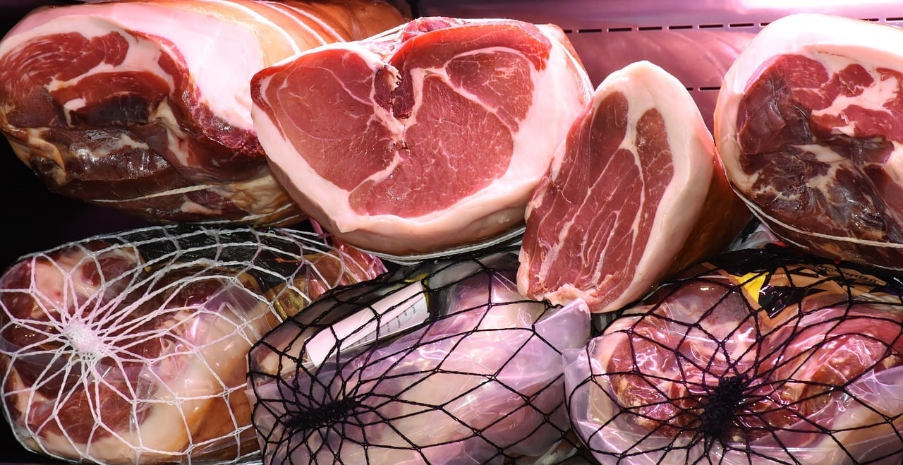 Assorted cured ham cuts in deli display