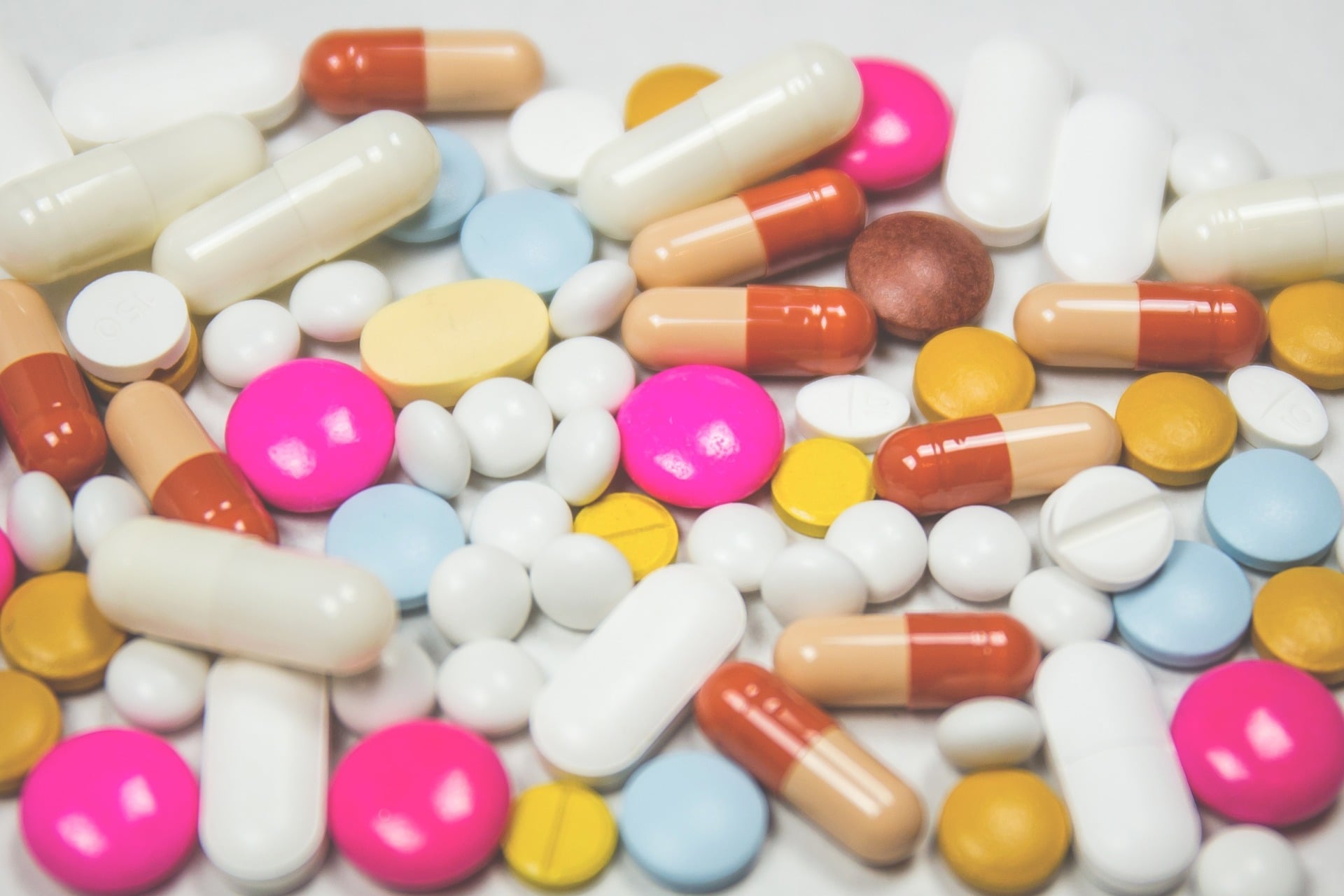 Assorted colourful pills and capsules scattered together