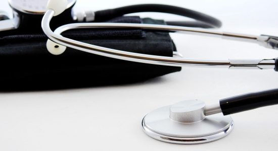 Stethoscope resting on blood pressure cuff